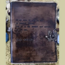 Zápisník s vyraženým citátem na kožených deskách “It Is Good to Have an End to Journey Towards; But It Is the Journey That Matters, in the End”